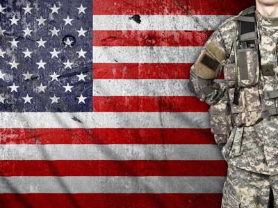 soldier standing in front of American flag